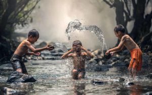 enfants vivants jouant dans l'eau